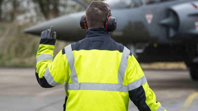 Un Aviateur guidant un Mirage 2000D au sol.
