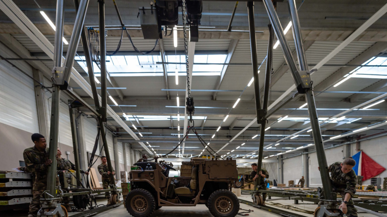 Dans le hangar du PNOAP, les soldats du 1er RTP conditionnent le matériel aérolarguable.
