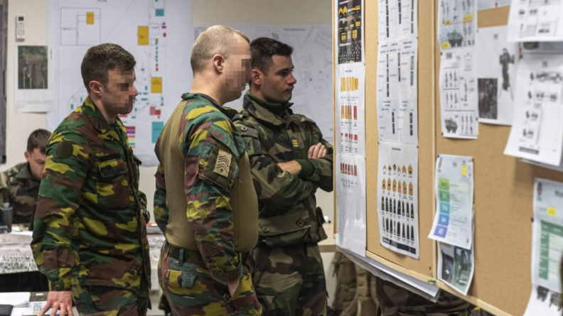 Deux soldats belges et un français assistent à un point de situation au centre des opérations.