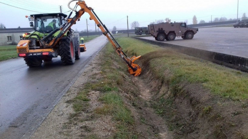 Un tracteur nettoie un fossé.