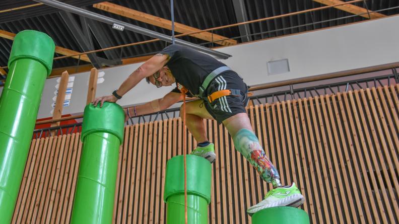 Un participant amputé d’une demie jambe franchissant un obstacle de piliers disposés en escalier