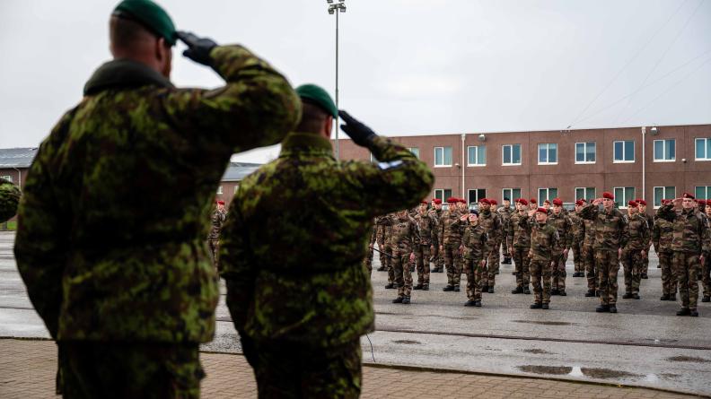 La compagnie d’infanterie légère saluant, au second plan, visible derrière deux soldats estoniens 