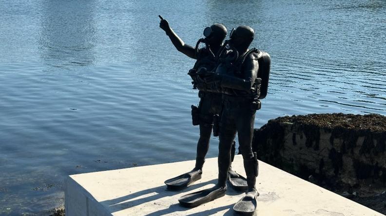 La statue sur socle représentant un binôme de nageurs de combat en activité de plongée