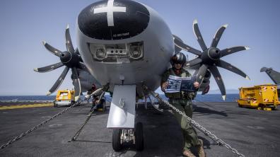 Pilote de Hawkeye lisant un Cols bleus sur le pont d'envol du porte-avions Charles de Gaulle
