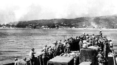 Une unité de débarquement chargée de véhicules et de soldats approche d'une plage, à l'est de Toulon