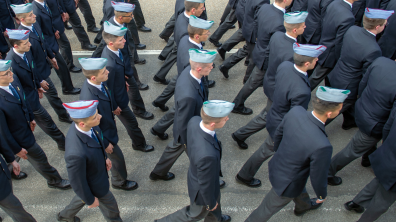 Vue aérienne de lycéens militaires défilant en blazer et calot