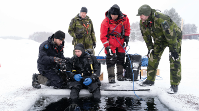 Le lieutenant Julien supervisé par un instructeur suédois vérifie l’équipement du plongeur.