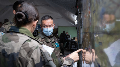 Une militaire française explique sa manoeuvre à deux militaires français.